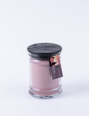 The Bridgewater Candle Company Hello Night 8oz Jar Candle features pink soy-blend wax, a black lid, and a sunset tag with two people. Its white background makes it perfect for enjoying signature Bridgewater fragrance.