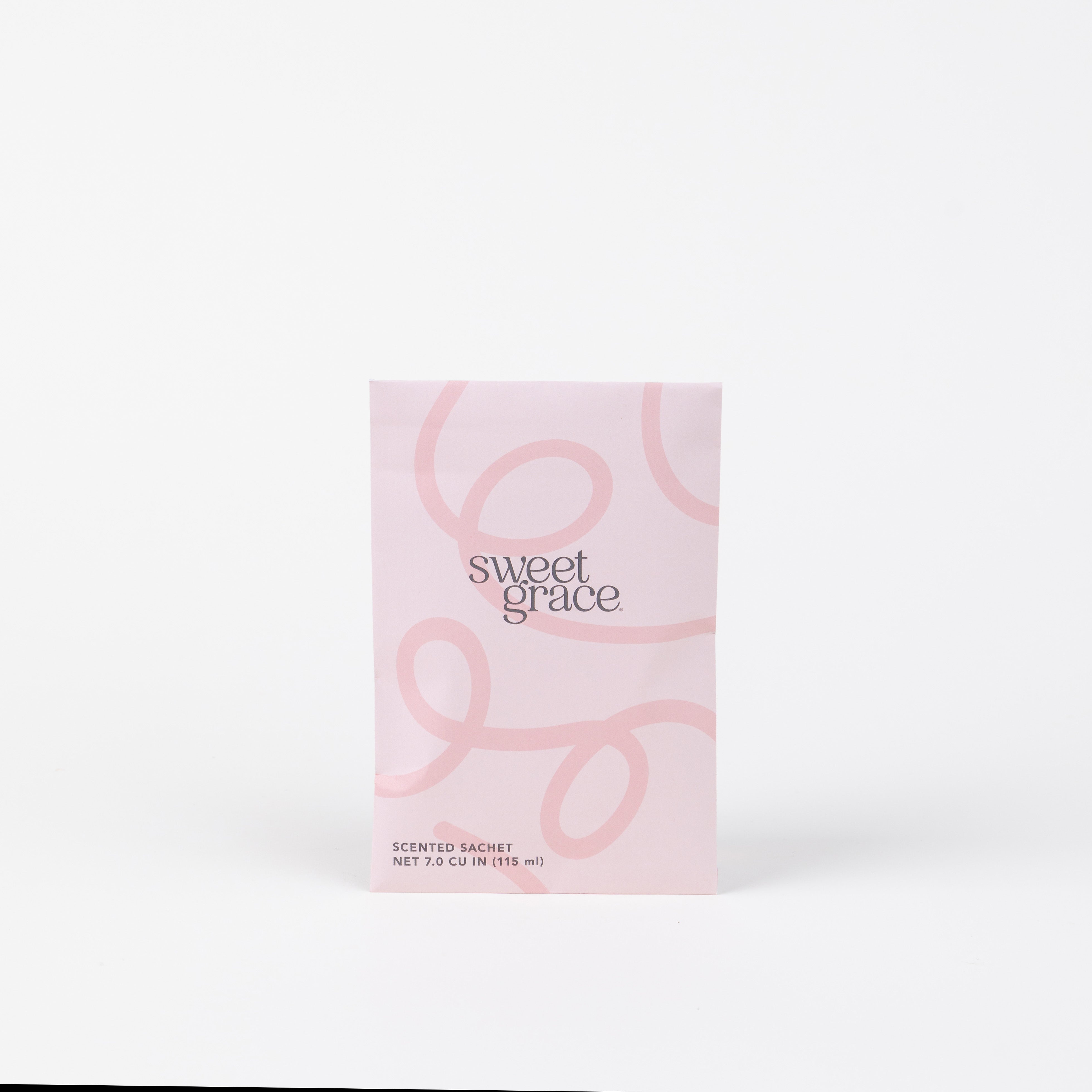 The Sweet Grace Modern Swirl Sachet by Bridgewater Candle Company features a pink minimalist design with light swirls, standing upright on a white background—perfect for adding a stylish, fragrant touch to any room.