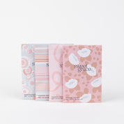 Four Sweet Grace Modern Swirl Sachets from Bridgewater Candle Company stand in a row, each with abstract pastel designs. The front packet features a pink and white floral leopard print—ideal for infusing your home with Sweet Grace fragrance.