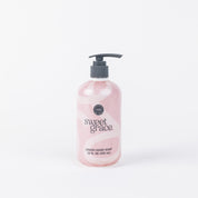 A pink bottle of Bridgewater Candle Companys Sweet Grace Liquid Soap with a black pump (12 FL OZ/355 ml) sits on a plain white background—ideal for a fragrant hand wash experience.