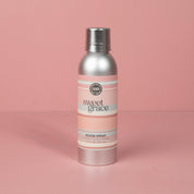 A silver can of Bridgewater Candle Company’s Sweet Grace Non-Aerosol Room Spray with a pink label stands upright against a plain pink background, bringing stylish elegance to your home fragrance routine.