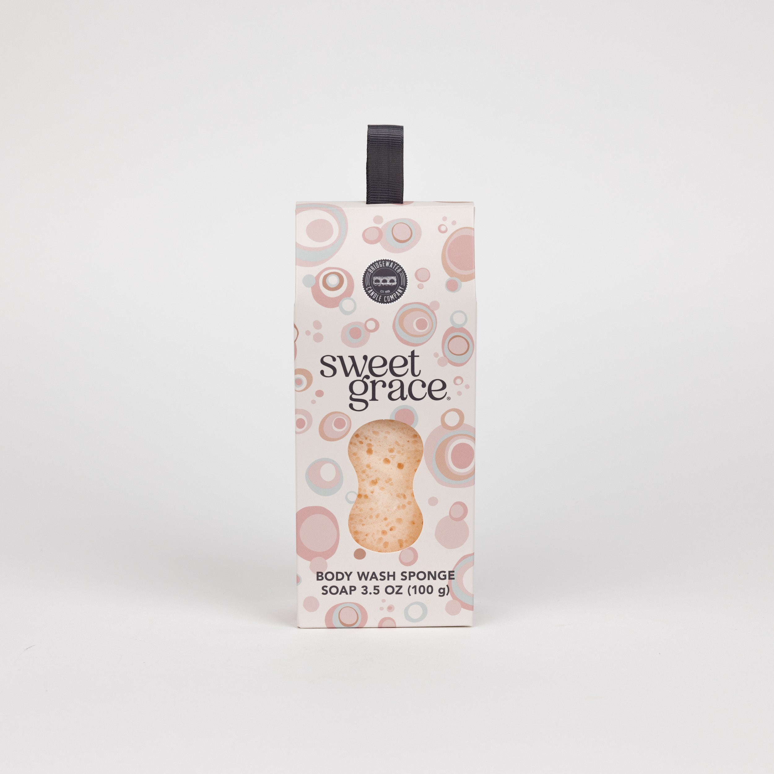 The Bridgewater Candle Sweet Grace Body Wash Sponge, 3.5 oz (100 g), features a pink and brown bubble design with a black hanging ribbon, delivering creamy lather and gentle exfoliation, shown on a white background.