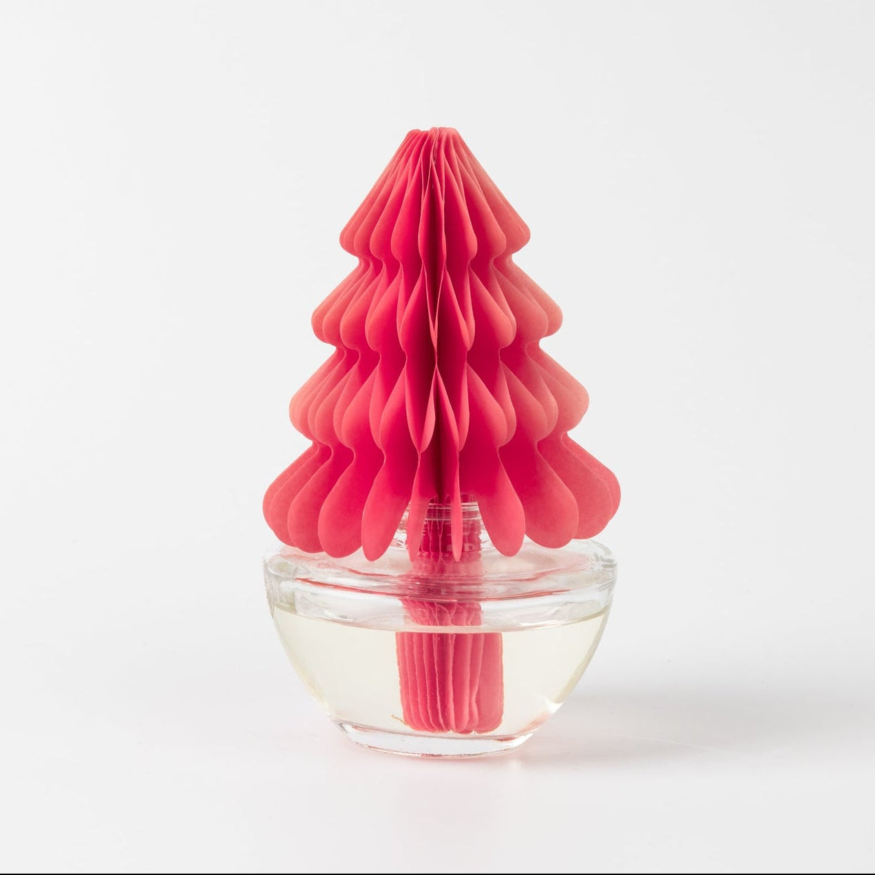 The Bridgewater Candle Sweet Grace Holiday Honeycomb Diffuser features a pink paper Christmas tree in a clear glass jar with fragrance liquid, offering long-lasting aroma, displayed on a plain white background.