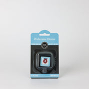 A square Bridgewater Candle Auto Vent Clip-Welcome Home in a blue and black hanging retail package featuring a picture of a wreath on a door.