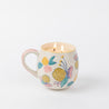 The Bridgewater Candle Sweet Grace Mug Candle features a floral yellow, pink, and blue mug. With two wicks, it glows warmly and doubles as a charming candle holder—perfect for gifting.