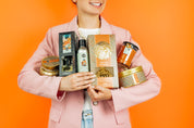 Person holding various Harvest Pumpkin products against an orange background