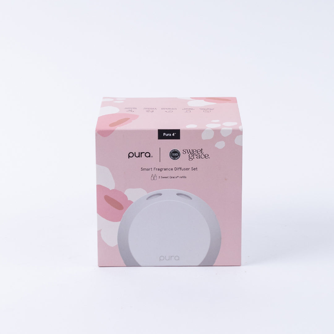 A pink box displays the Pura + Bridgewater Sweet Grace Lovers Kit by Bridgewater Candle Company, featuring floral patterns and branding on a clean white background.