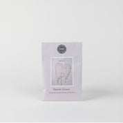 The Sweet Grace Sachet by Bridgewater Candle Company features soft white angel wings on a plain white background, making it the perfect home fragrance accent.