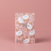 The Bridgewater Candle Company Sweet Grace Modern Flower Sachet stands upright in pink packaging with white abstract flowers and beige spots, labeled SCENTED SACHET NET 7.0 CU IN (115 ml)—ideal for home fragrance lovers.