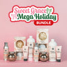 Fast Bundle’s Sweet Grace Mega Holiday Bundle—featuring candles, lotions, and sprays—is arranged on a pink surface beneath a festive sign with bow decorations, making it an ideal holiday gift choice.