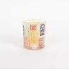 The Bridgewater Candle Sweet Grace Holiday House Candle features white soy-blend wax in a glass holder adorned with colorful house illustrations, all set against a plain white background.