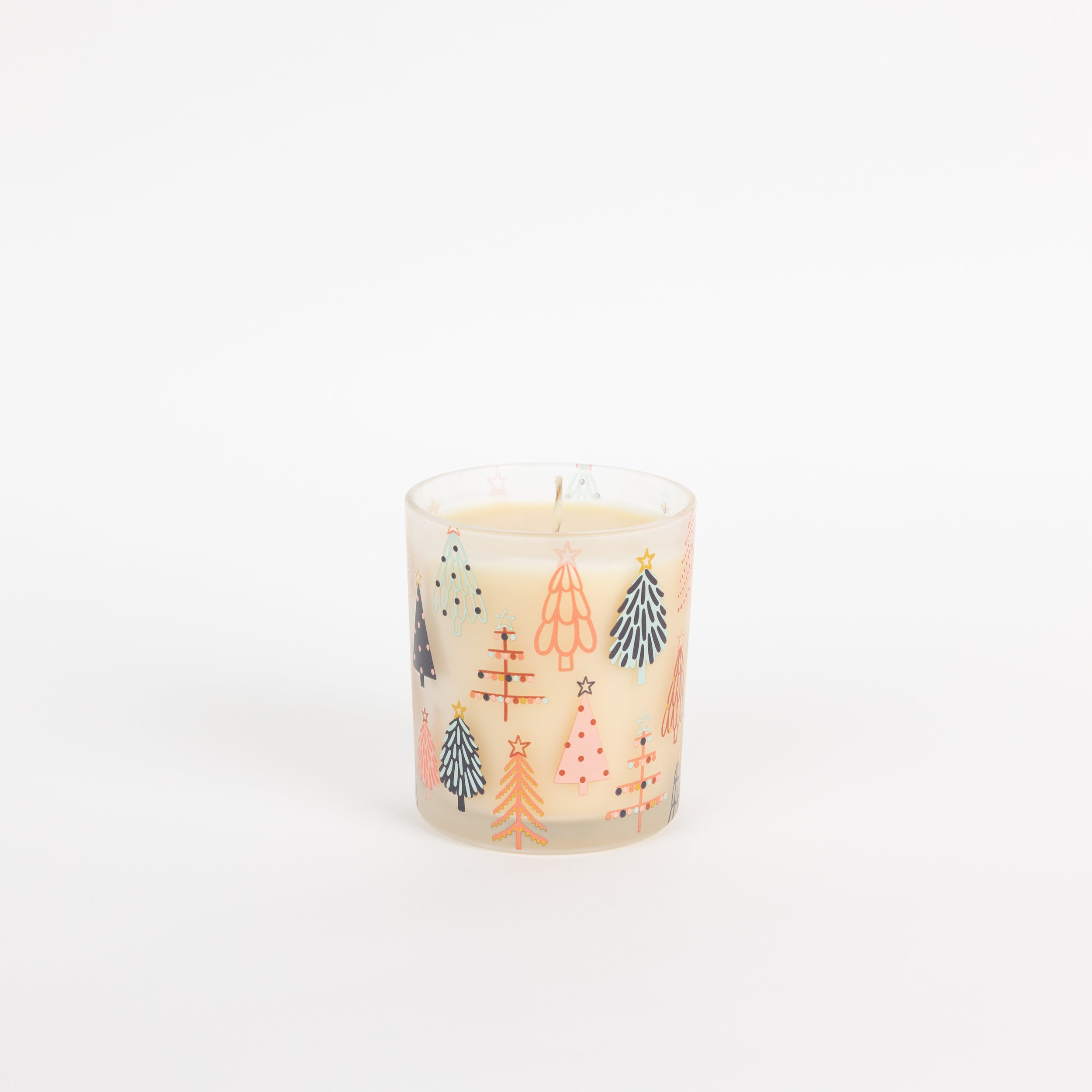 The Bridgewater Candle Sweet Grace Holiday Tree Candle features a white soy-blend wax in a glass holder adorned with colorful, stylized Christmas trees on a plain white background.