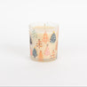 The Bridgewater Candle Sweet Grace Holiday Tree Candle features a white soy-blend wax in a glass holder adorned with colorful, stylized Christmas trees on a plain white background.