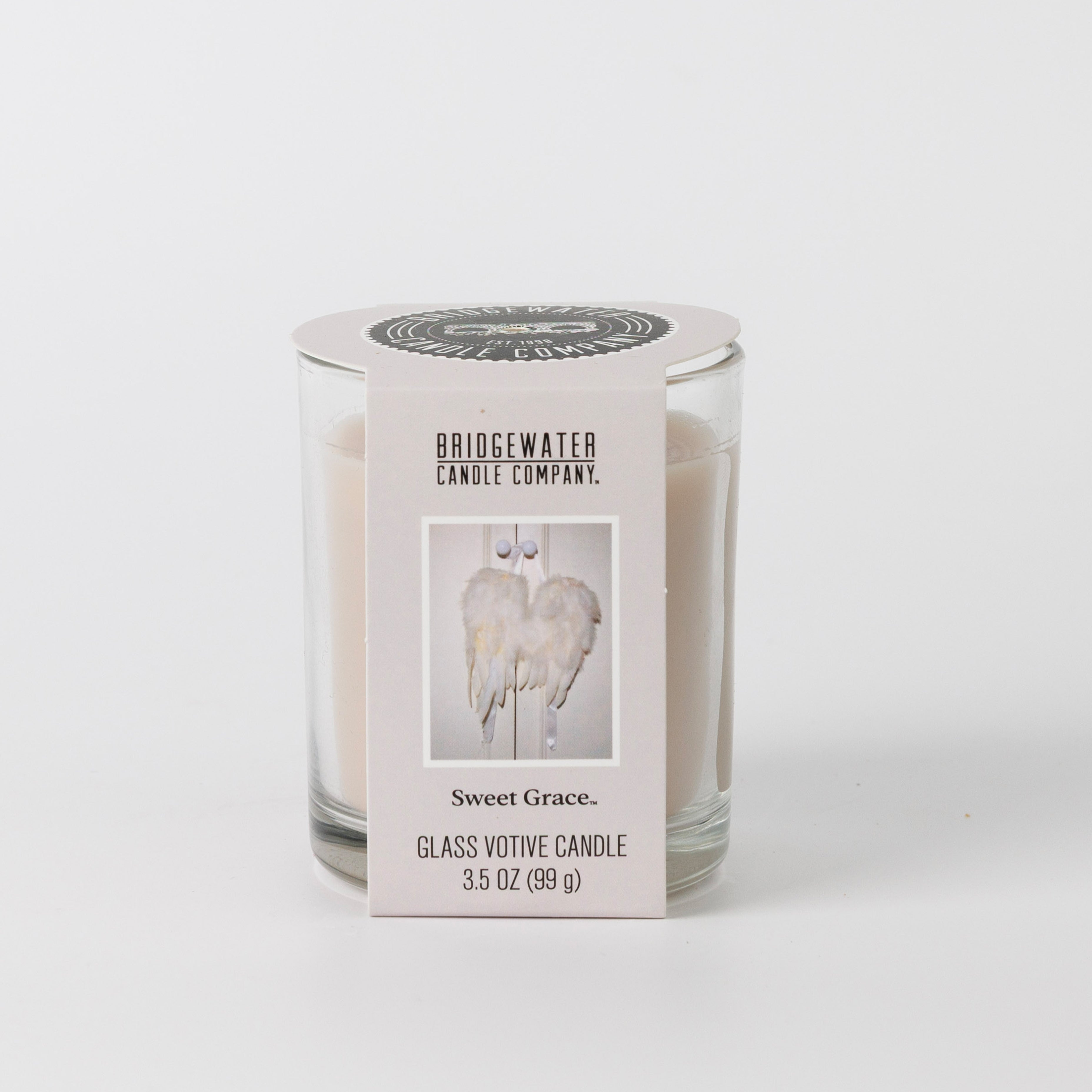 The Bridgewater Candle Sweet Grace Votive Candle (3.5 oz) features angel wings on its white glass and fills your space with the inviting Sweet Grace fragrance for a cozy ambiance.