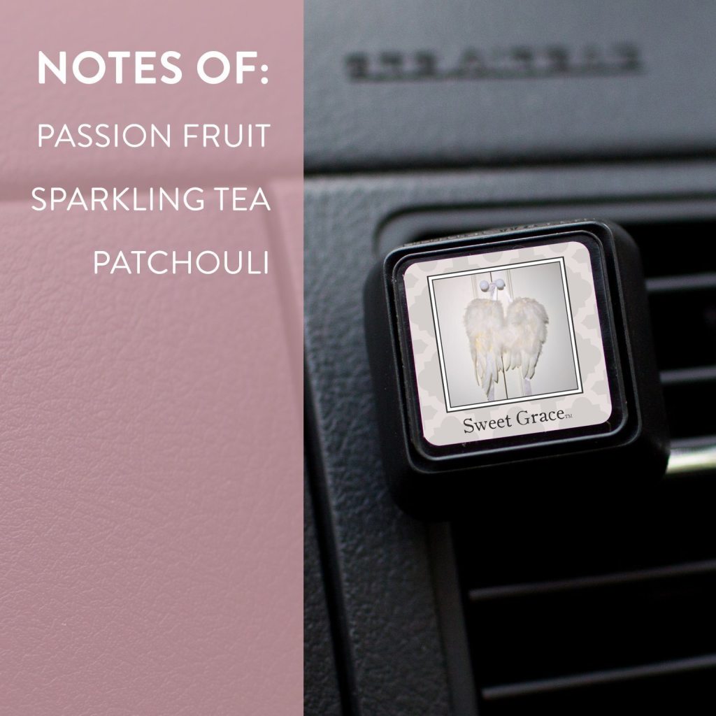 A Sweet Grace Auto Vent Clip by Bridgewater Candle Company, featuring angel wings, fills your car with passion fruit, sparkling tea, and patchouli fragrance notes against a pink backdrop.