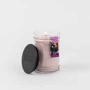 A Kiss in the Rain 18oz Large Jar Candle by Bridgewater Candle Company sits beside its black lid, featuring a purple tag with a dog and cat image. The simple white background highlights this signature fragrance.