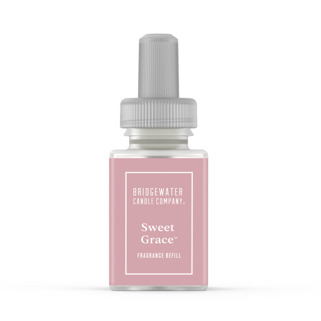 A Pura + Bridgewater Fragrance Refill - Sweet Grace by Bridgewater Candle Company with a pink label and gray cap stands on a white background, ideal for use in your favorite home fragrance diffuser.