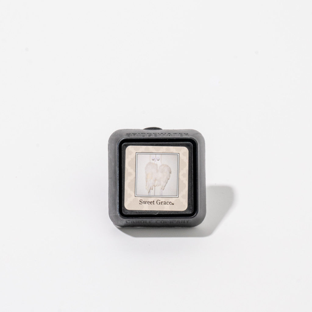 The Bridgewater Candle Company Sweet Grace Auto Vent Clip is a small square air freshener with a gray frame and a label showing white angel wings over the text, designed for car vents and displayed on a plain white background.