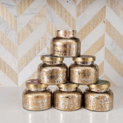 Six Bridgewater Candle Company Sweet Grace Mercury Jar Candles, featuring soy-blend wax, are stacked in a pyramid on a white countertop with a white and gold chevron tile backsplash in the background.