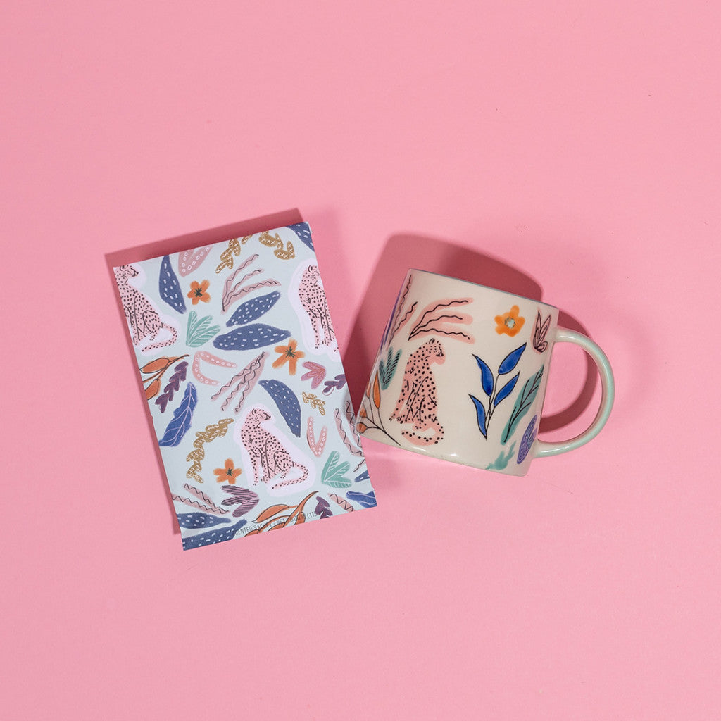 A Sweet Grace Collection Candle #048 by Bridgewater Candle Company is showcased on a pink background, highlighting its elegant design and coordinated packaging.