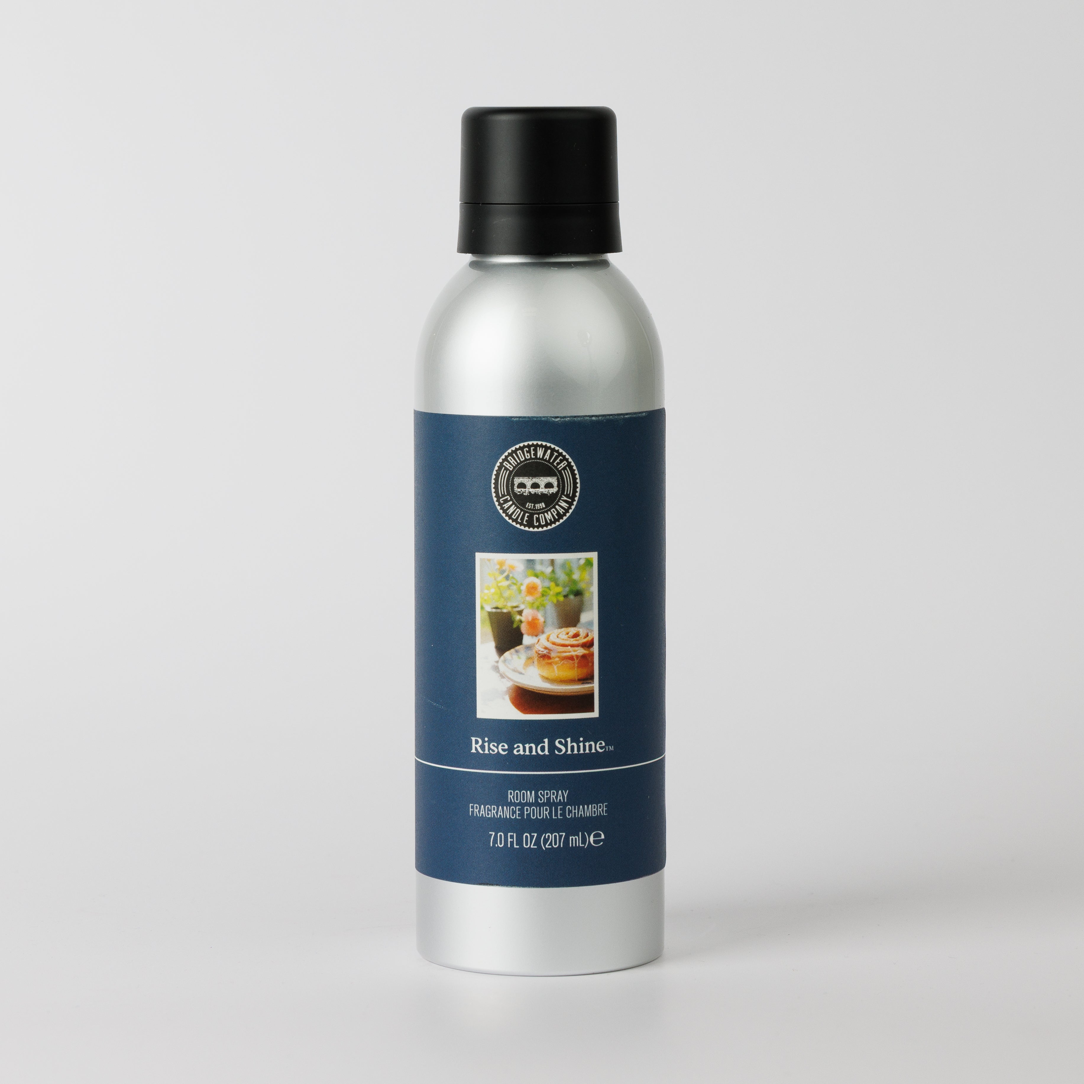 Bridgewater Candle’s Rise & Shine Non-Aerosol Room Spray comes in a 7 oz silver bottle with a black cap and navy blue label. Enjoy a cozy cinnamon roll scent inspired by breakfast foods and floral decor in this eco-friendly fragrance.