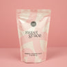 A pink and white resealable bag of Bridgewater Candle's Sweet Grace Soaking Salts with Pink Himalayan Sea Salt, 2 lb (907 g), stands upright against a matching pink background.