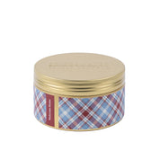 The Bridgewater Candle Company’s Welcome Home 3-Wick Tin Candle features a gold lid, blue/red/white plaid sides, and a “Welcome Home” label, all set against a white background.