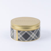 A round metal tin with a gold lid and a plaid gray, black, and white label displays Afternoon Retreat 3-Wick Tin Candle by Bridgewater Candle Company. The soy-blend wax candle is shown against a plain white background.