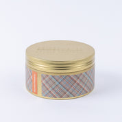 Against a plain white background, the Bridgewater Candle Company Harvest Pumpkin 3-Wick Tin Candle is displayed in a gold tin container featuring a plaid patterned label with orange accents.