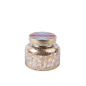 The Welcome Home Mercury Jar Candle by Bridgewater Candle Company comes in a gold and silver speckled glass jar with a gold lid, topped with red and blue plaid, and is filled with soy-blend wax.