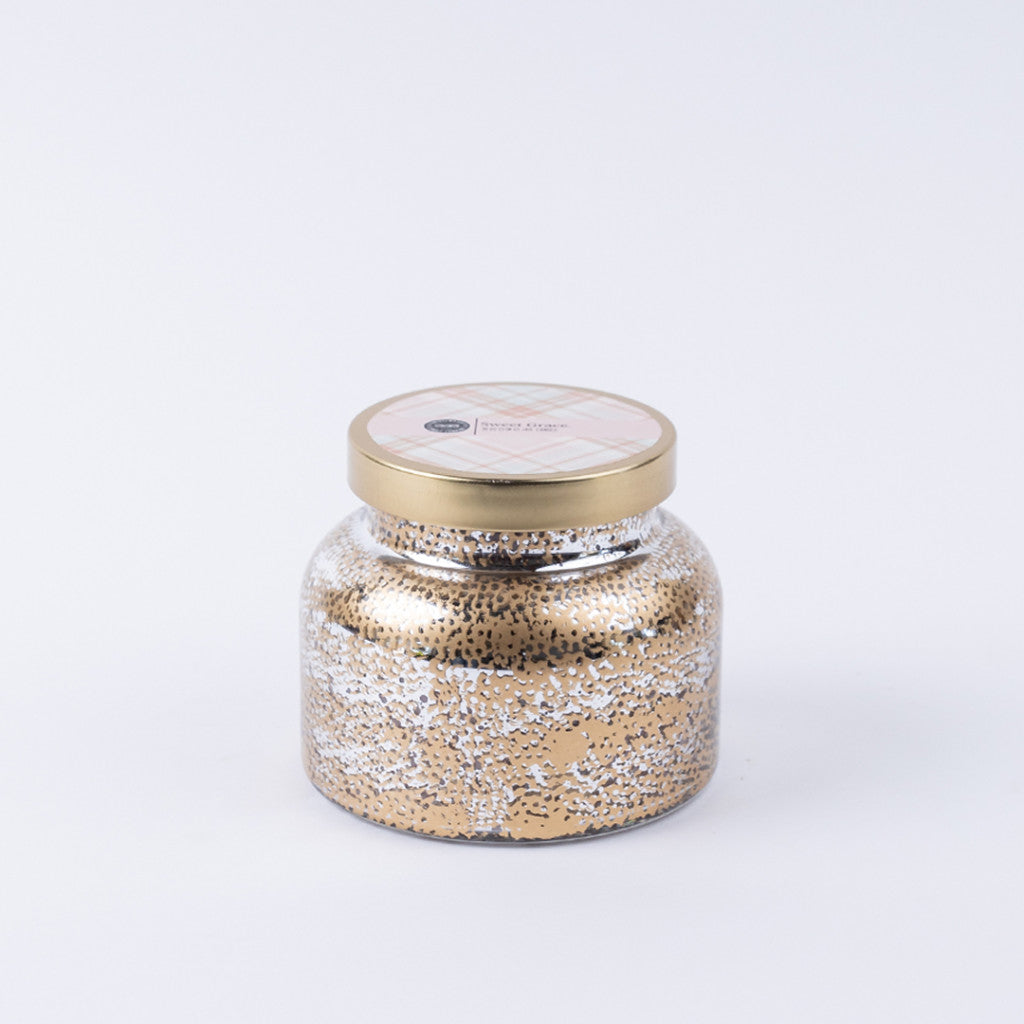 The Bridgewater Candle Company Sweet Grace Mercury Jar Candle features gold and silver speckles, a round gold lid, and soy-blend wax, shown against a plain white background.