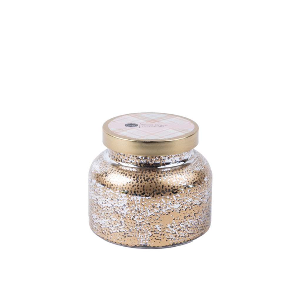 The Bridgewater Candle Company Sweet Grace Mercury Jar Candle features a round jar with a gold lid and metallic gold and white speckles. Made from soy-blend wax, it is displayed against a plain white background.