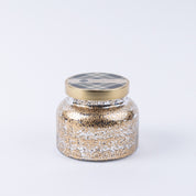 The Bridgewater Candle Companys Afternoon Retreat Mercury Jar Candle features a gold lid and gold-silver speckled soy-blend wax in a decorative jar—an elegant accent for any home decor, shown against a plain white background.