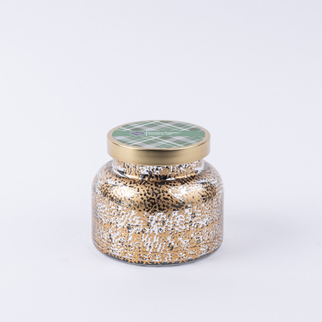 The Bridgewater Candle Company Festive Frasier Holiday Mercury Jar Candle features a decorative glass jar with a gold metal lid, green plaid label, and soy-blend wax flecked in gold and white, shown against a plain white background.