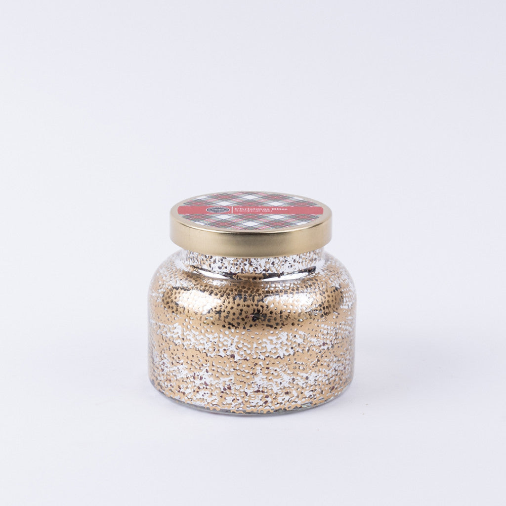 The Bridgewater Candle Company Christmas Bliss Holiday Mercury Jar Candle features gold and silver speckled soy-blend wax in a festive jar with a gold lid, perfect for bringing the spirit of Christmas to your space.