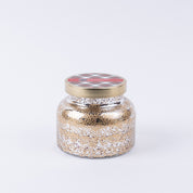The Bridgewater Candle Company Christmas Bliss Holiday Mercury Jar Candle features gold and silver speckled soy-blend wax in a festive jar with a gold lid, perfect for bringing the spirit of Christmas to your space.