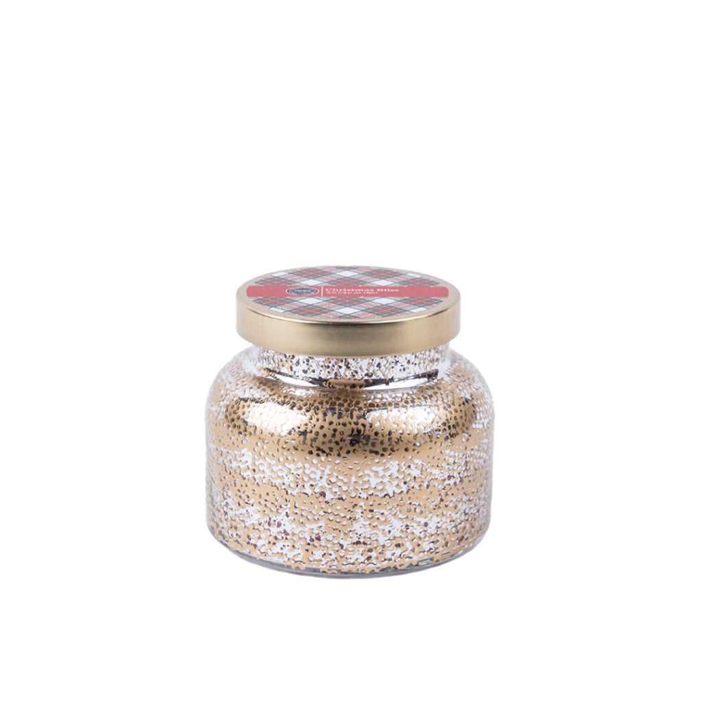 The Christmas Bliss Holiday Mercury Jar Candle by Bridgewater Candle Company features a gold metallic lid with a red and black patterned label and is filled with gold and silver glitter—perfect for festive décor. Displayed against a plain white background.