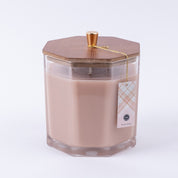 The Bridgewater Candle Company Sweet Grace Large Decorative Candle features beige soy-blend wax in a hexagonal glass jar with a wooden lid and gold knob. A plaid tag is attached with a gold string, all shown on a plain white background.