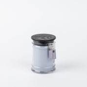 The Bridgewater Candle Company Lavender Fields 8oz Small Jar Candle features pale lavender wax in a glass jar with a black textured lid and lavender tag, filling your space with the serene scent of lavender fields.