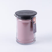 The Hello Night 18oz Jar Candle by Bridgewater Candle Company features pink soy-blend wax in a clear glass jar with black embossed lid and hanging tag showing branding and product details. Background is plain white.