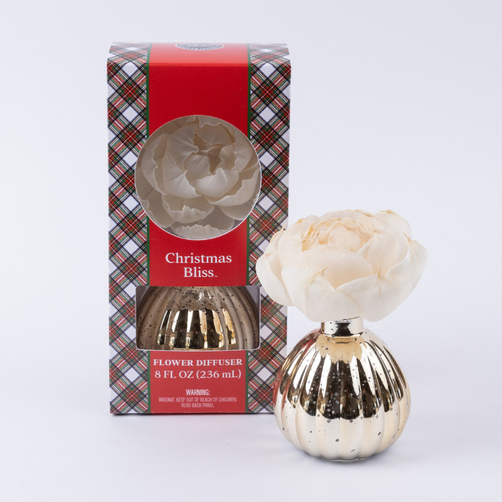 The Bridgewater Candle Company Christmas Bliss Holiday Mercury Flower Diffuser features a gold striped mercury finish and cream flower, shown beside its festive red and plaid holiday box.