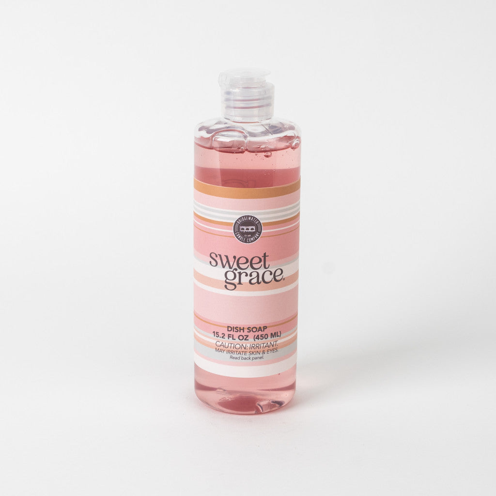 A clear bottle of Bridgewater Candle Company Sweet Grace Dish Soap with a white cap and a label featuring pastel pink and white stripes. The best-selling fragrance is highlighted, and the product is displayed on a plain white background.