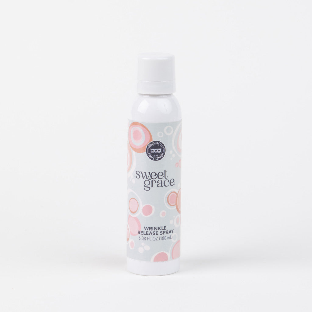 A white bottle of Bridgewater Candle Company’s Sweet Grace Wrinkle Release Spray with a gray and pink circular design stands upright against a white background, ideal for refreshing and smoothing fabrics.