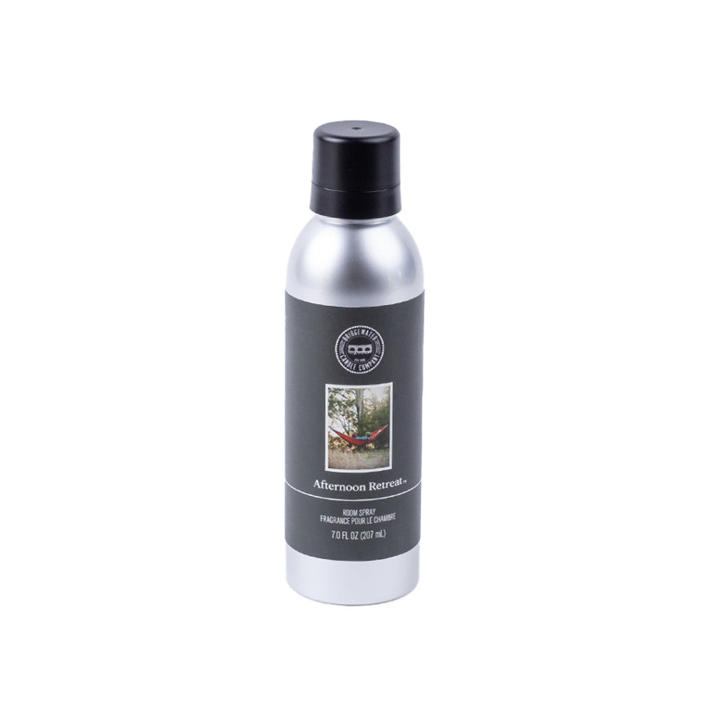 A 7 oz Afternoon Retreat Non-Aerosol Room Spray by Bridgewater Candle Company, in a silver can with black cap and label featuring trees and premium home fragrance, is shown on a white background.