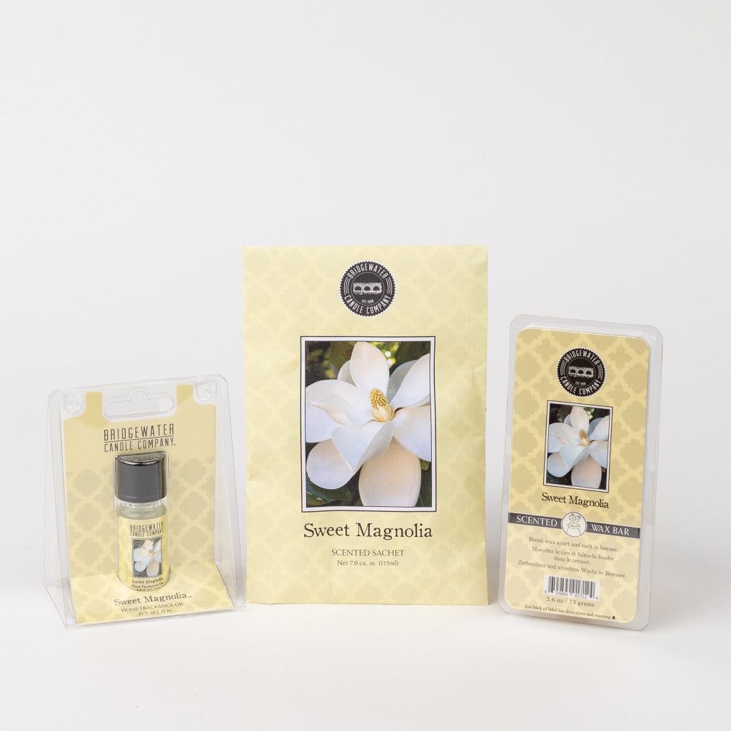 The Sweet Magnolia Flameless Bundle by Bridgewater Candle Company includes a fragrance oil, scented sachet, and wax bar, each decorated with a white magnolia flower and yellow patterned background.