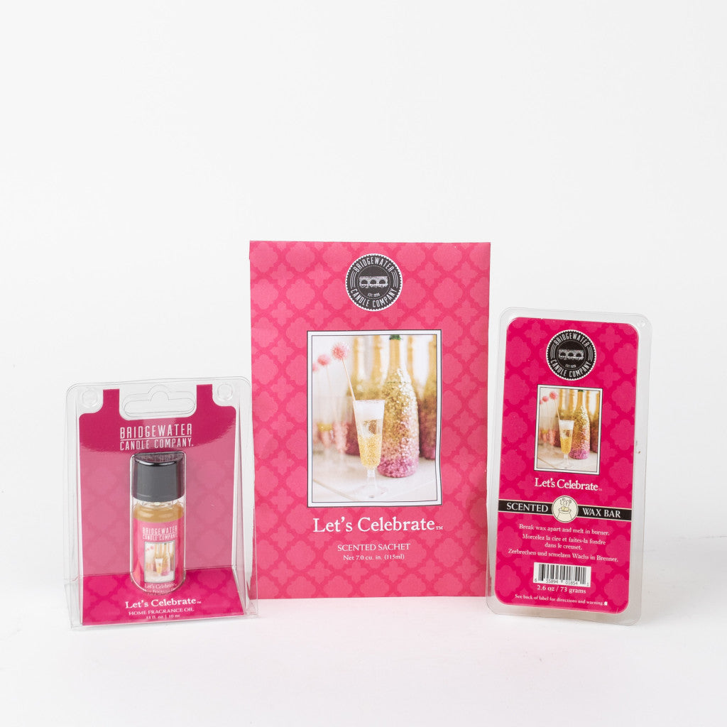 The Bridgewater Candle Company Let’s Celebrate Flameless Bundle includes a jar candle in packaging, a scented sachet, and a wax bar, all decorated with champagne images and festive accents.