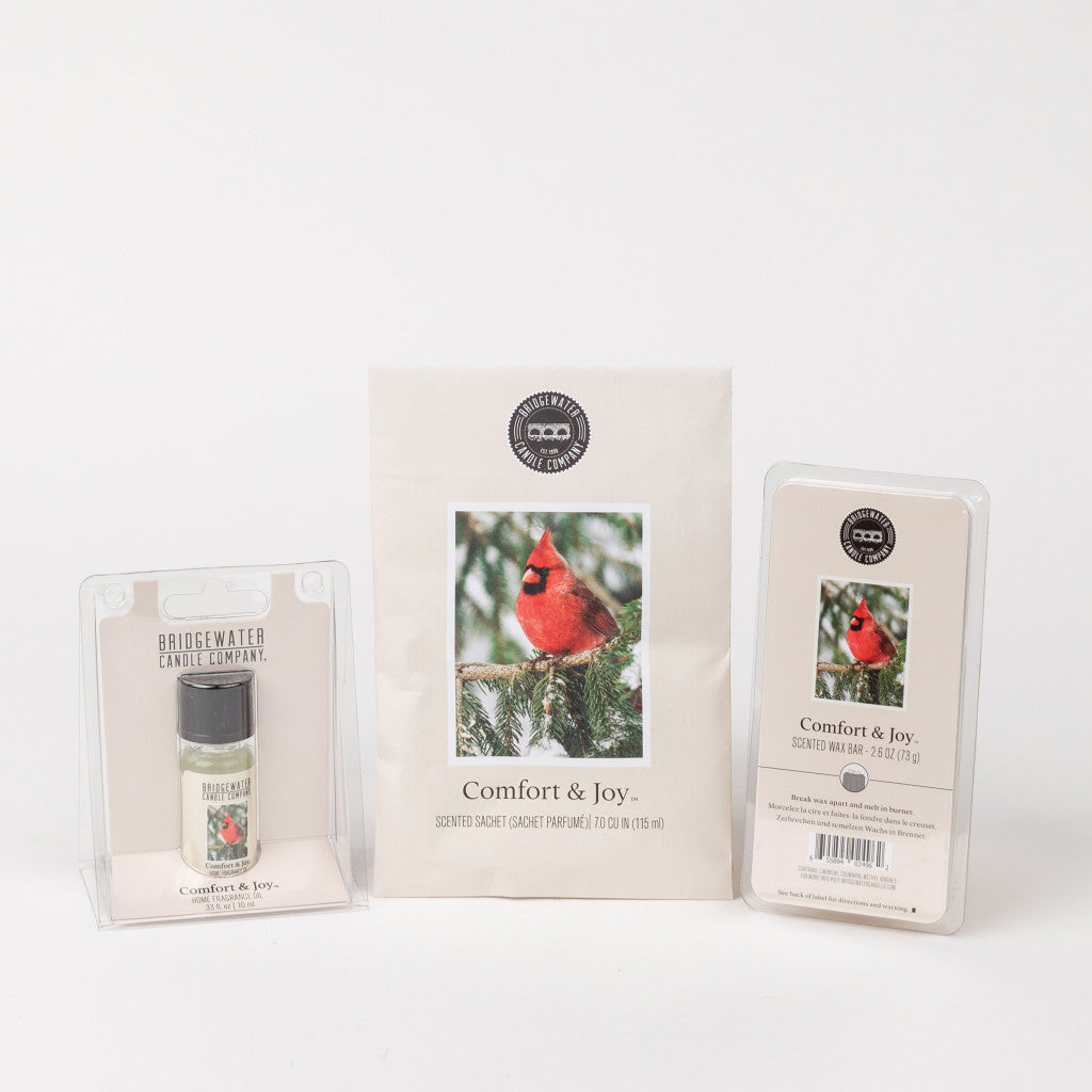 The Bridgewater Candle Company Comfort & Joy Flameless Bundle includes a scented sachet with a cardinal design, home fragrance oil in clear packaging, and scented wax bars in a plastic container.