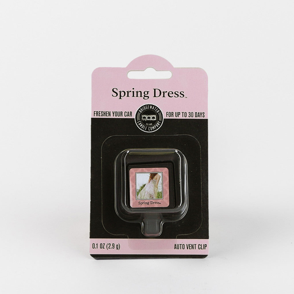 The Bridgewater Candle Company Spring Dress Auto Vent Clip, in a pink and black blister pack with a floral design, offers up to 30 days of fresh fragrance for your car. Net weight: 0.1 oz (2.9 g).