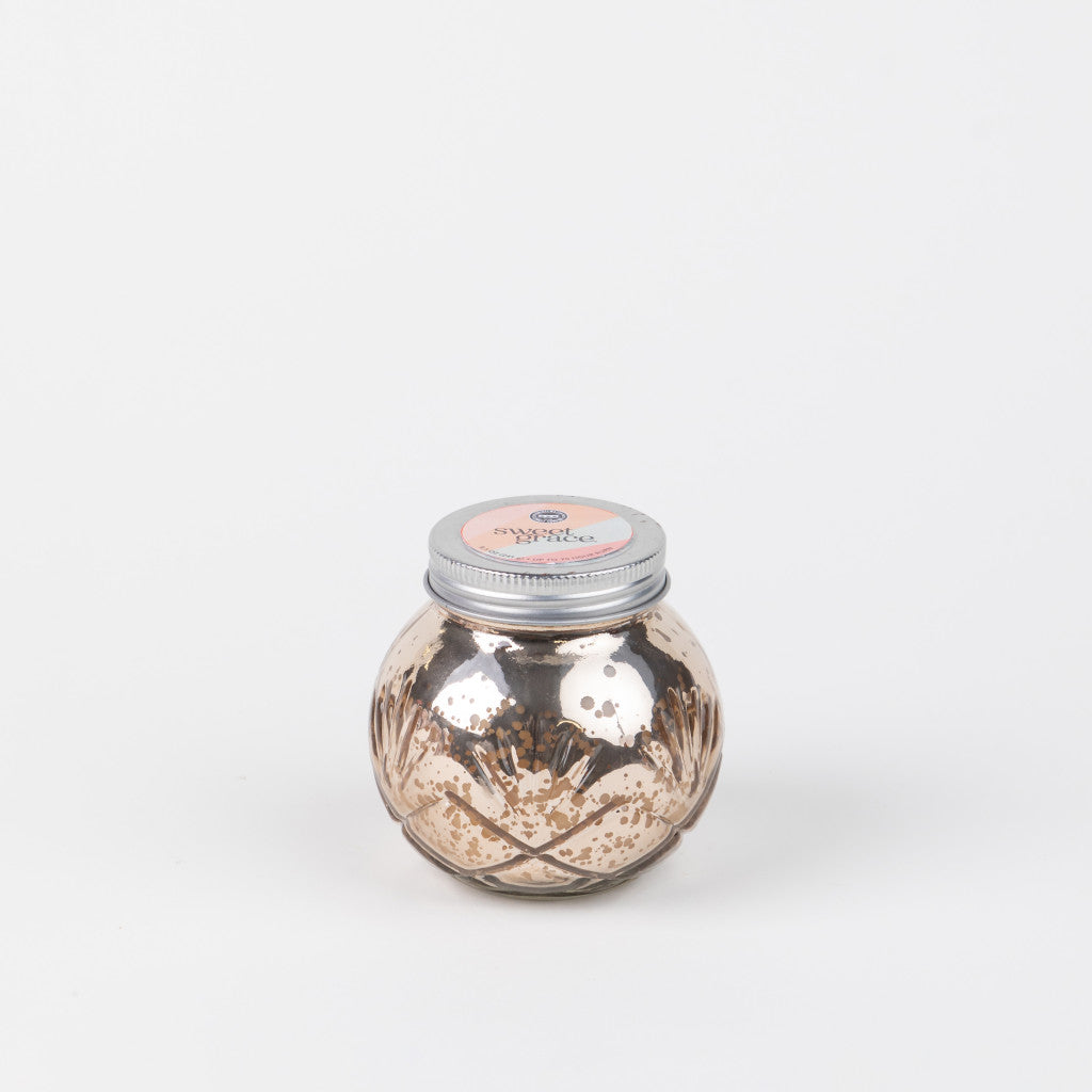 The Sweet Grace Collection Candle #008 by Bridgewater Candle Company features a round, metallic gold jar with a silver lid and pink label, crafted from soy-blend wax and shown against a plain white background.