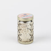 A clear glass jar with a gold lid, labeled Sweet Grace Collection Candle #022 by Bridgewater Candle Company, features a textured diamond pattern and stands empty on a plain white background.
